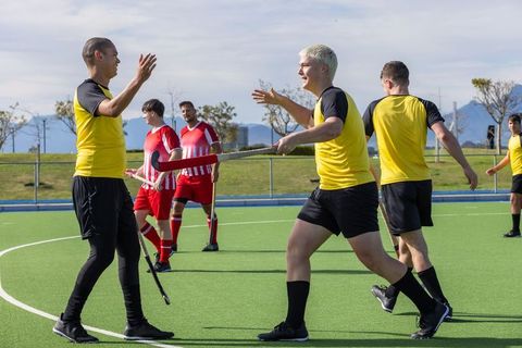 Field hockey players celebrating victory on synthetic turf