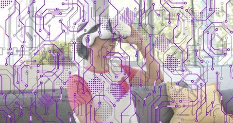 Young Asian man adjusting VR headset on sofa with purple circuit overlay and headphones