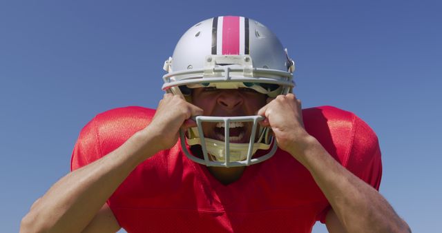 Football player expressing excitement and energy, wearing full gear with red jersey and helmet. Perfect for illustrating passion in sports, promoting football events, sports advertisements, motivational posters and team spirit campaigns.