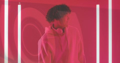 Trendy Young Man with Headphones in Neon Red Light