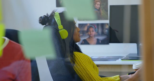 Woman wearing green headphones working in modern home office - Download Free Stock Images Pikwizard.com