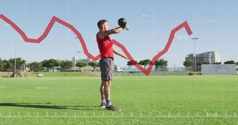 Athlete lifting kettlebell on grass field with red performance analytics graph overlay