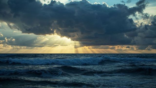 Dramatic Sun Rays Over Majestic Churning Ocean Waves