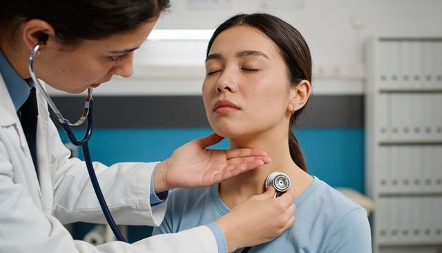 Doctor listening to patient chest with stethoscope during routine clinical examination