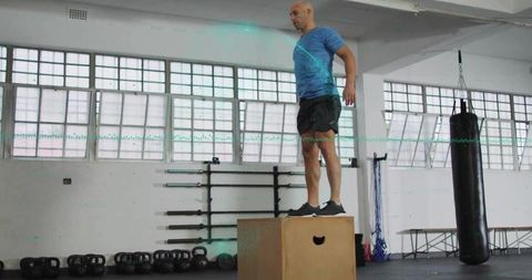Athletic Coach Performing Box Jump Exercise at Gym