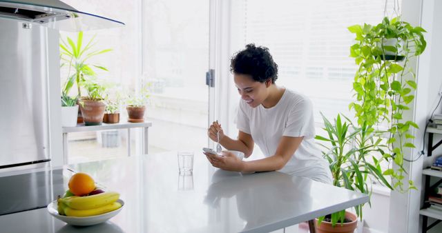 Person enjoying breakfast at modern bright kitchen counter - Download Free Stock Images Pikwizard.com