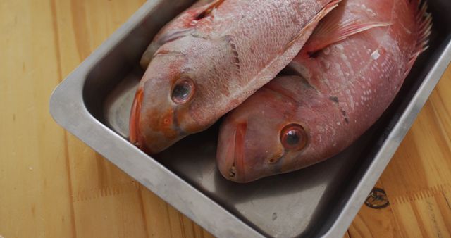 Two fishes lying in a pan, ready to be cooked. cooking and having fun in a kitchen.