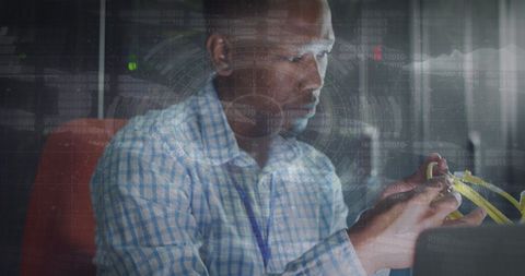 Technician analyzing data with futuristic interface in server room