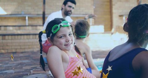 Smiling child at poolside learning from swim instructor outdoors