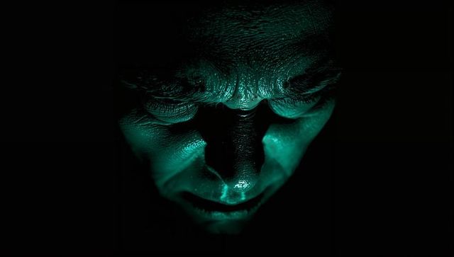Green underlit male portrait showing dramatic skin texture, wrinkles and specular highlights