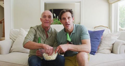 Father and Son enjoying TV Time Together on Cozy Sofa