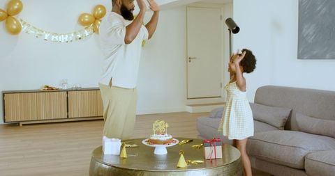 Father and daughter celebrating birthday at home with great joy