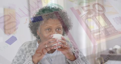 Senior woman enjoying tea amidst euro currency overlay