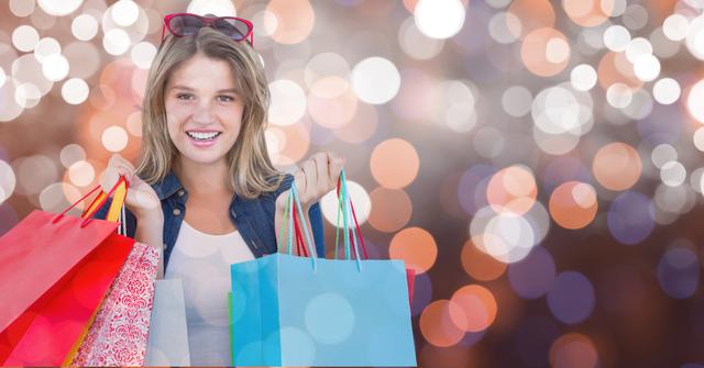 Portrait of woman smiling while holding shopping bags over bokeh - Download Free Stock Photos Pikwizard.com
