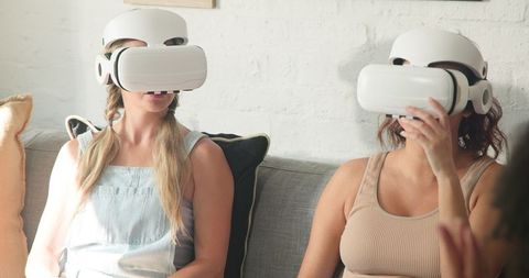 Women enjoying virtual reality in modern living room setting