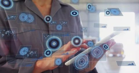 Mid-adult woman holding tablet using augmented reality hud for industrial data analytics