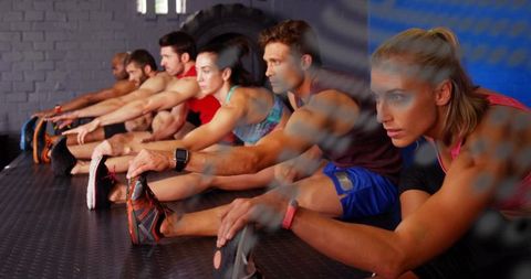 Group stretching class in industrial gym improving flexibility, mobility and team motivation