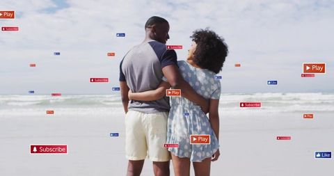 Couple embracing on beach with social icons showing likes, subscribe and play buttons