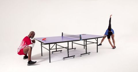 Diverse men stretching by ping-pong table fitness and teamwork