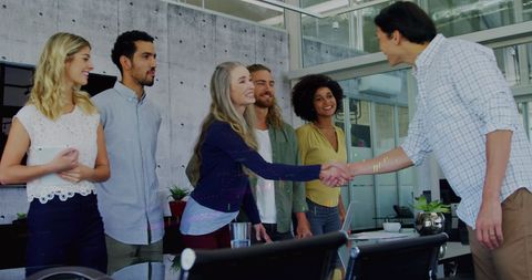 Diverse business team handshaking in modern office environment