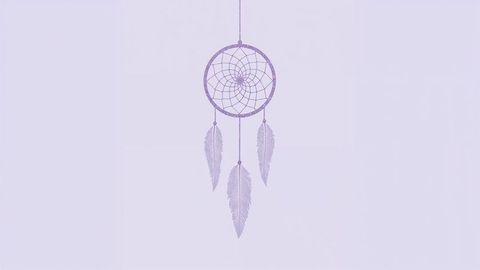 Purle dreamcatcher with feathers and beads against lavender wall