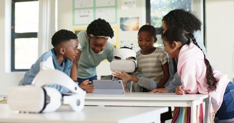 African american children exploring virtual reality with tablet, collaborating in classroom