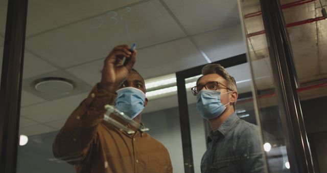 Colleagues Discussing on Glass Board While Wearing Face Masks in Office - Download Free Stock Images Pikwizard.com