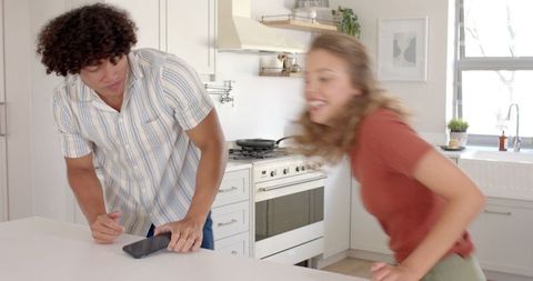 Young Couple Using Smartphone in Modern Kitchen Interior