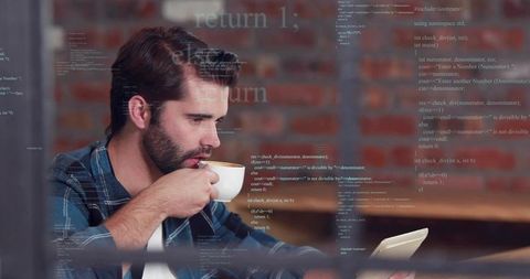 Bearded man drinking espresso while reading tablet with floating code in coworking brick wall