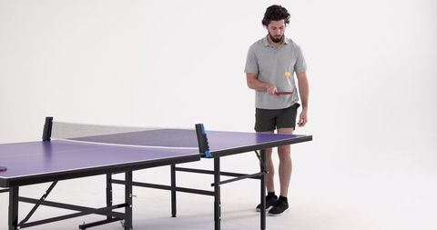 Man Engaging in Ping-Pong Activity with Purple Table