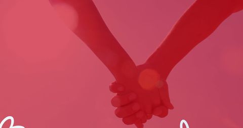 Romantic Hand Holding Against Warm Pink Background