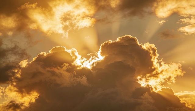 Glowing cumulonimbus cloud at golden hour casting dramatic sunbeams and crepuscular rays