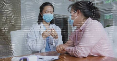 Masked clinician preparing vaccine behind dotted partition during patient consultation