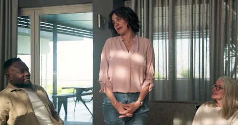 Middle-Aged Woman Leading Group Therapy Session with Smiling Participants