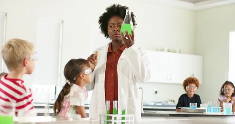 African American Teacher Demonstrating Chemistry Experiment to Curious Elementary Students