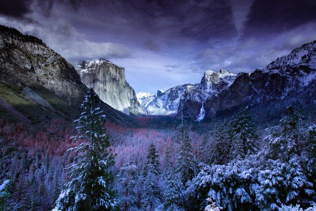 Stunning winter scene showcasing Yosemite National Park during dusk. Snow-covered trees and mountains under a dramatically lit sky make for a breathtaking view. Ideal for travel blogs, nature magazines, promotional materials for winter travel destinations, or posters celebrating natural beauty.