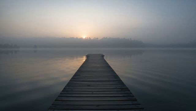 Tranquil Morning Mist over Wooden Pier at Serene Lake