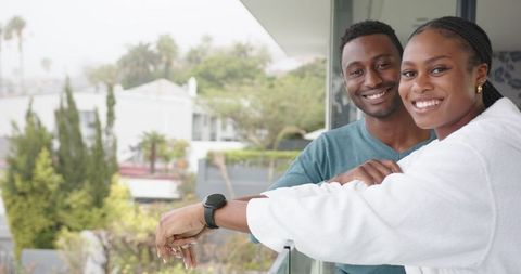 Happy Couple Relaxing Leaning on Balcony with Scenic View