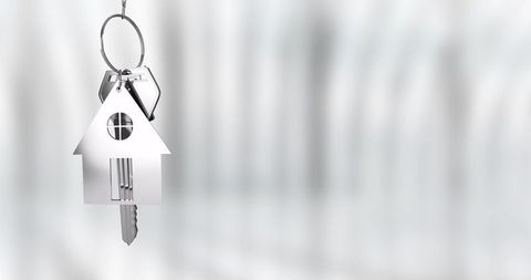 Chrome house keychain hanging with key on ring minimalist real estate concept