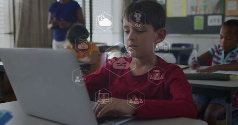 Focused Student Working on Laptop in Classroom