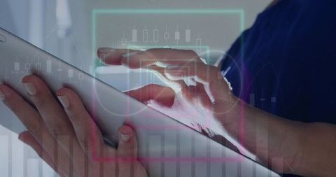 Hands tapping tablet with financial graph overlays in business environment