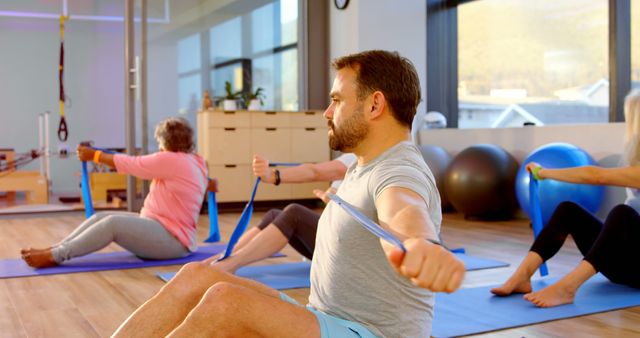 Group Fitness Class Exercising with Resistance Bands in Bright Studio - Download Free Stock Images Pikwizard.com