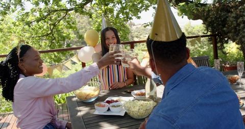 Friends celebrating birthday in sunny garden gathering