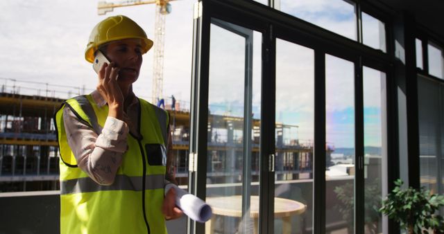 Female construction engineer discussing project on-site with architectural plans - Download Free Stock Images Pikwizard.com