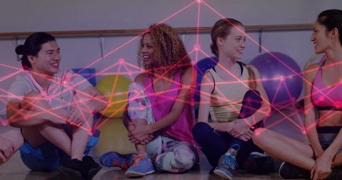 Diverse women resting and laughing after barre workout in studio with neon network overlay