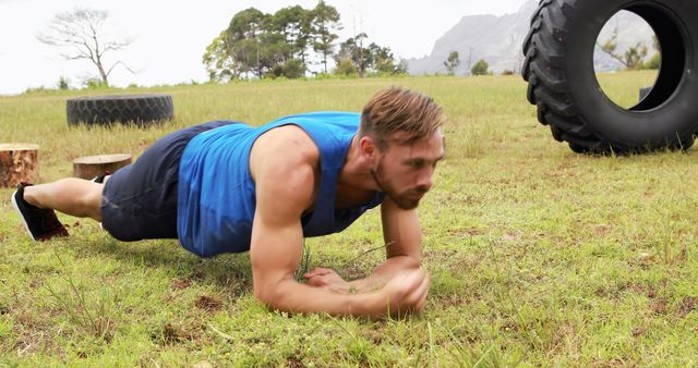 Fit Man Training Outdoors with Tire Obstacles and Planking Exercise - Download Free Stock Images Pikwizard.com