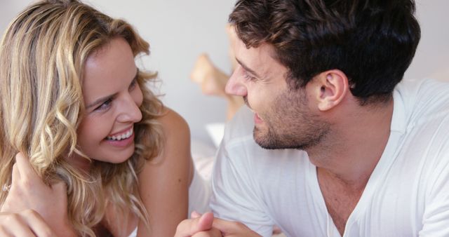 Happy couple relaxing on bed and looking at each other lovingly - Download Free Stock Images Pikwizard.com