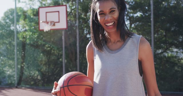 Smiling Woman Holding Basketball on Outdoor Court - Download Free Stock Images Pikwizard.com