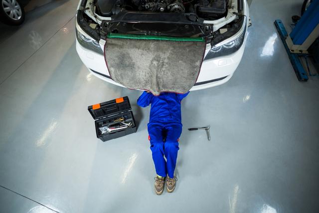 Female mechanic repairing a car in repair garage