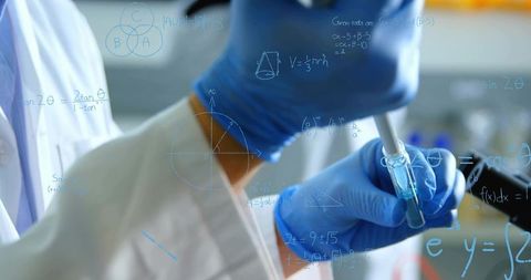 Scientist using micropipette with blue nitrile gloves pipetting liquid for research